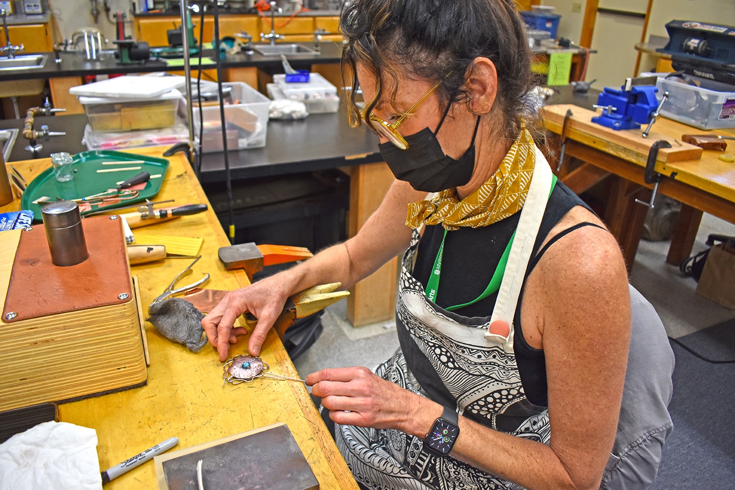 student metalsmith at a machine